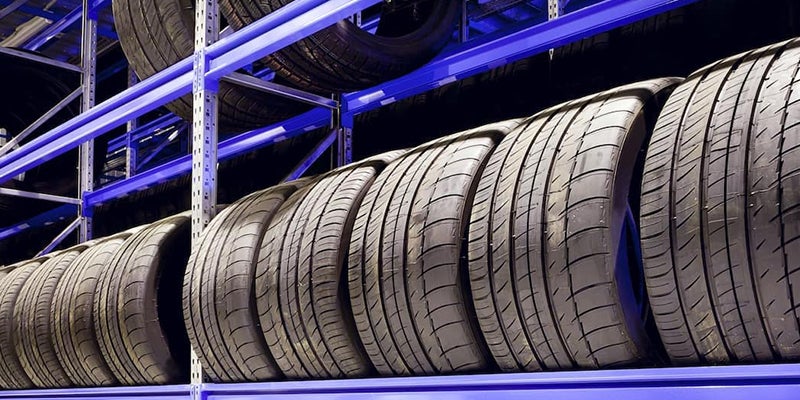 Rows of car tires neatly stacked on blue-lit shelves. Learn more about tire care at 495 Mazda’s service tips and tricks page.